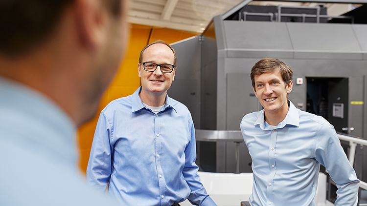 Two training participants smile at a trainer